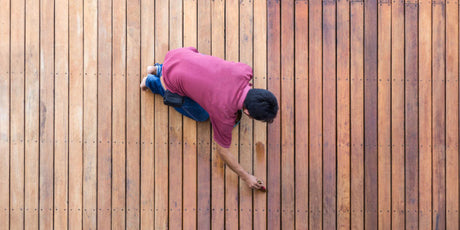 A man fixing the discoloration of a deck