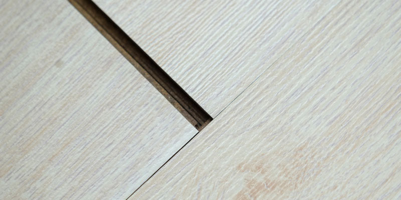 A close-up of a wooden floor. The image showcases the hardwood floor gaps.