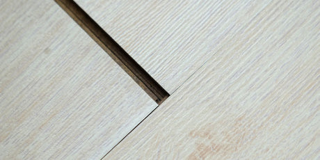 A close-up of a wooden floor. The image showcases the hardwood floor gaps.
