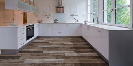 White cabinets and wood flooring in a trendy kitchen. Choose between vinyl or laminate!